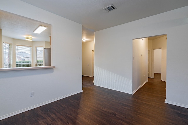 spare room with visible vents, baseboards, and wood finished floors