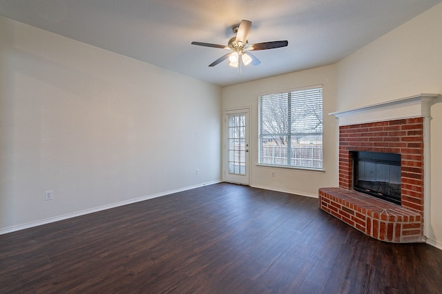 unfurnished living room with a ceiling fan, a fireplace, dark wood-style flooring, and baseboards