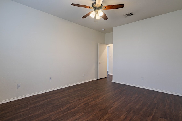 unfurnished room featuring a ceiling fan, dark wood-style floors, visible vents, and baseboards