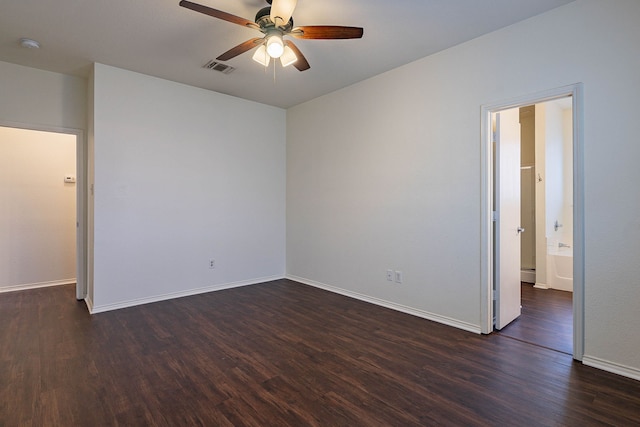 spare room featuring dark wood-style floors, baseboards, and a ceiling fan