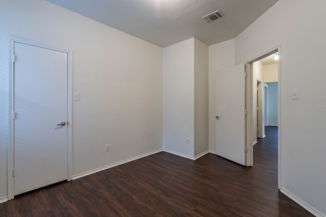 spare room with visible vents, baseboards, and wood finished floors