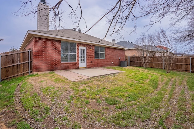 back of house featuring brick siding, a patio area, a lawn, and a fenced backyard