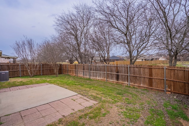 view of yard with a fenced backyard, central AC, and a patio