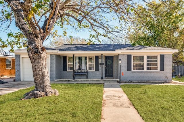 ranch-style house featuring a front yard, brick siding, concrete driveway, and an attached garage