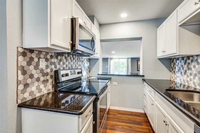 kitchen with tasteful backsplash, dark stone countertops, appliances with stainless steel finishes, dark wood-style floors, and white cabinets