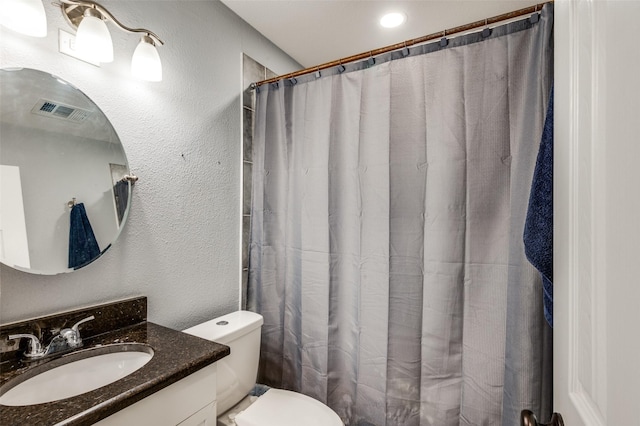 full bath with visible vents, curtained shower, toilet, a textured wall, and vanity