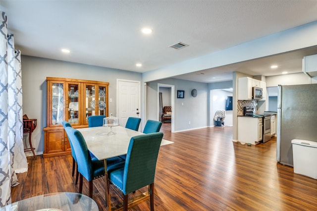 dining area with dark wood-type flooring, recessed lighting, and visible vents