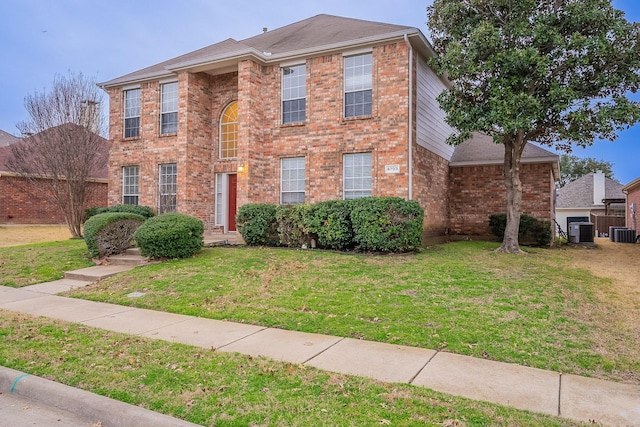 view of front of property featuring brick siding, central AC unit, and a front yard