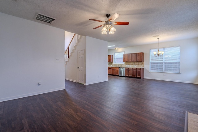 unfurnished living room with stairway, visible vents, baseboards, dark wood-type flooring, and ceiling fan with notable chandelier