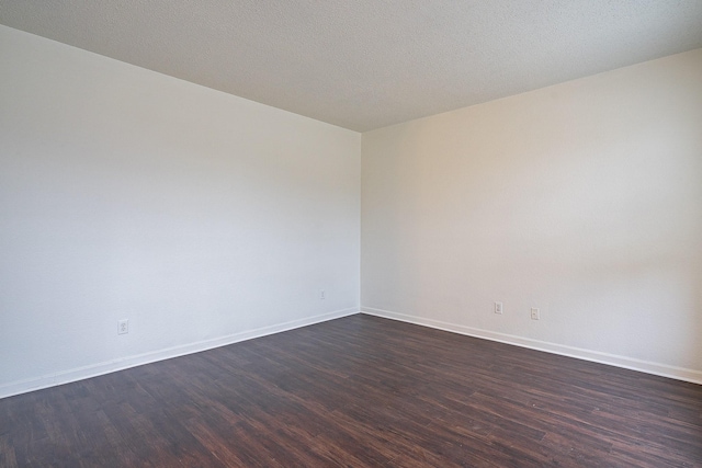 unfurnished room with dark wood finished floors, baseboards, and a textured ceiling