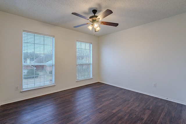 unfurnished room featuring dark wood-type flooring, a ceiling fan, baseboards, and a textured ceiling