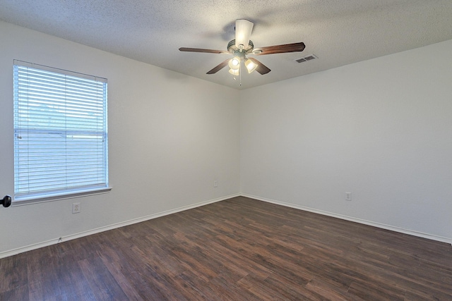 unfurnished room featuring baseboards, visible vents, dark wood finished floors, ceiling fan, and a textured ceiling