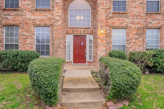 view of exterior entry featuring brick siding