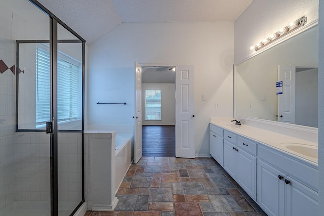 bathroom featuring double vanity, a garden tub, lofted ceiling, and a sink