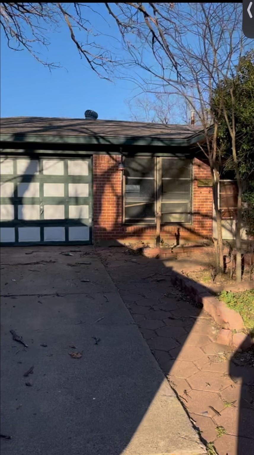 exterior space with a garage and brick siding