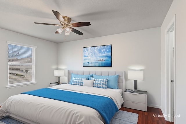 bedroom featuring baseboards, dark wood-type flooring, and ceiling fan