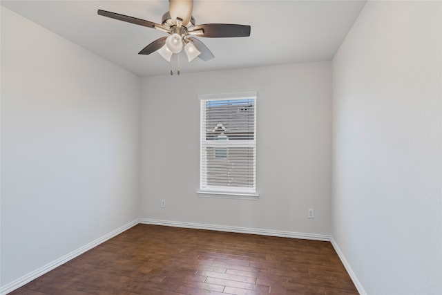 spare room featuring dark wood finished floors, a ceiling fan, and baseboards