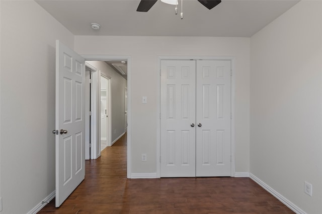 unfurnished bedroom featuring dark wood-type flooring, baseboards, a closet, and ceiling fan