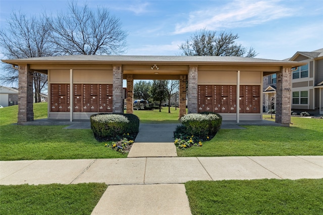 view of property's community featuring mail area and a lawn