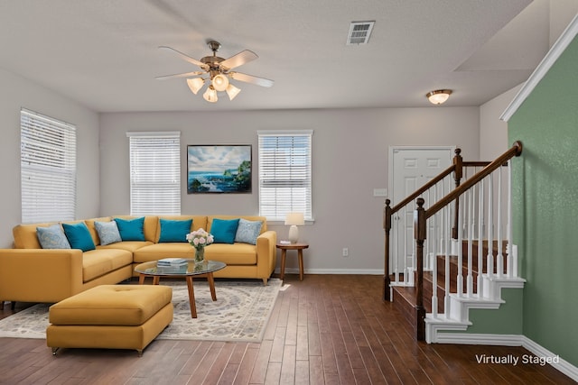 living room featuring visible vents, baseboards, ceiling fan, stairs, and wood finished floors