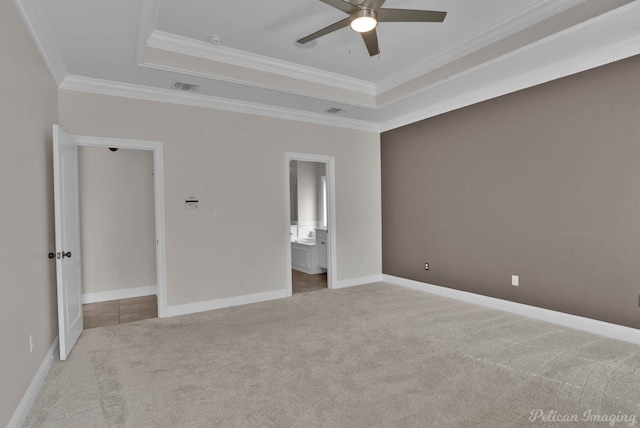 unfurnished bedroom featuring crown molding, baseboards, a raised ceiling, and carpet