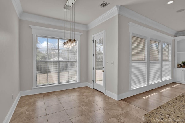 foyer with an inviting chandelier, crown molding, plenty of natural light, and visible vents