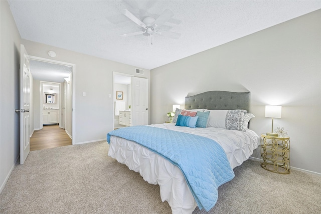 5831 Harvest Hill Rd Unit 1069, Dallas, TX 75230 - carpeted bedroom with a textured ceiling, ensuite bathroom, baseboards, and a ceiling fan