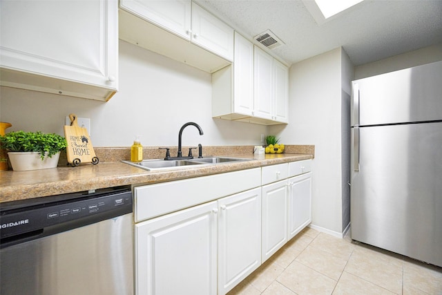 5831 Harvest Hill Rd Unit 1069, Dallas, TX 75230 - kitchen with appliances with stainless steel finishes, a sink, white cabinetry, and light tile patterned flooring