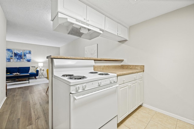 5831 Harvest Hill Rd Unit 1069, Dallas, TX 75230 - kitchen with white range with electric stovetop, under cabinet range hood, baseboards, white cabinets, and a textured ceiling
