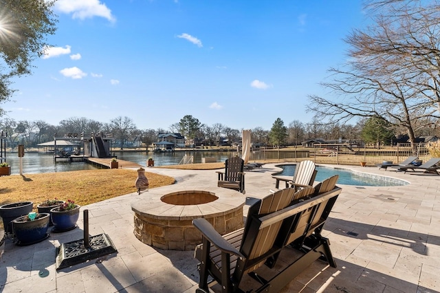 view of patio with a fenced in pool, fence, a water view, and an outdoor fire pit