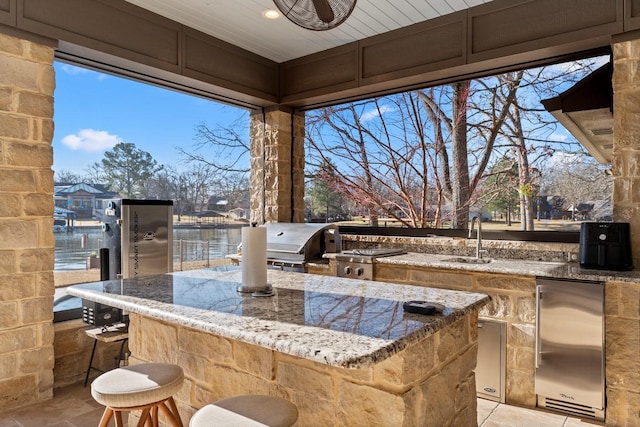 view of patio / terrace with an outdoor kitchen, outdoor wet bar, area for grilling, and a sink