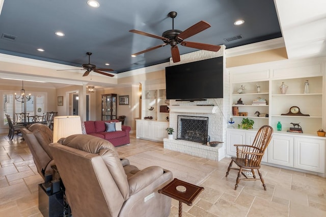 living room with stone tile floors, visible vents, a tray ceiling, and ornamental molding