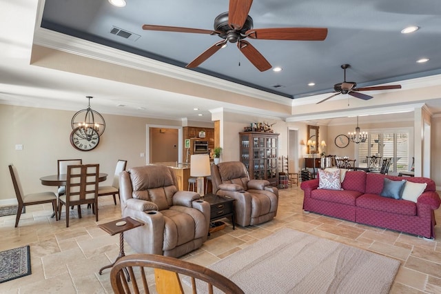 living area featuring stone tile flooring, visible vents, a tray ceiling, and ornamental molding