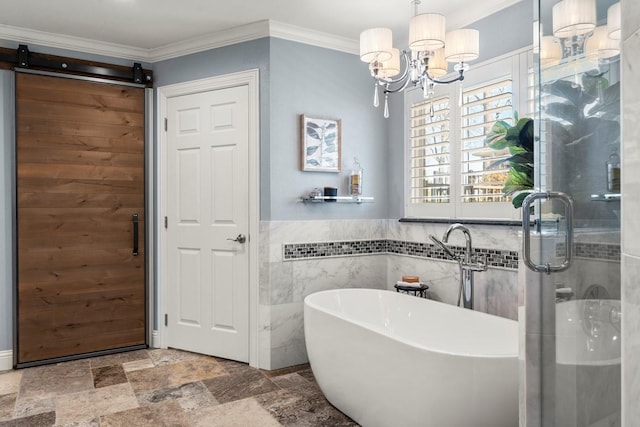 full bathroom featuring a freestanding tub, a shower stall, stone finish floor, crown molding, and a notable chandelier