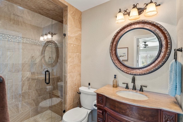 bathroom with vanity, toilet, a textured wall, and a stall shower