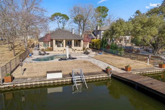 rear view of property featuring a patio, a fenced backyard, an outbuilding, and an exterior structure