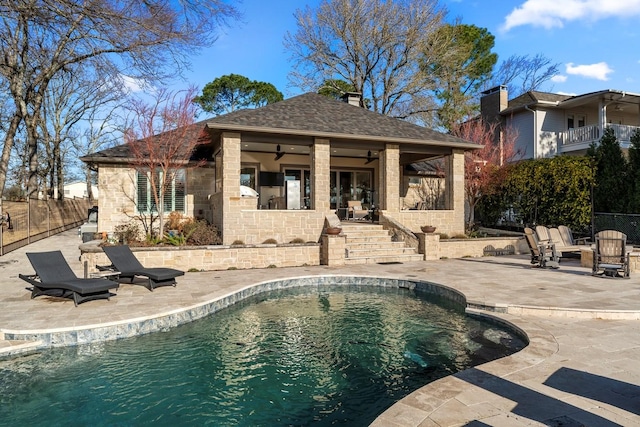 view of swimming pool with a patio area, a fenced in pool, an outbuilding, and fence