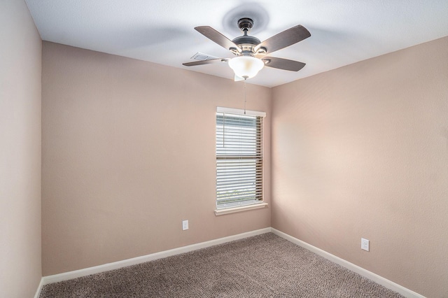 carpeted spare room featuring visible vents, baseboards, and ceiling fan