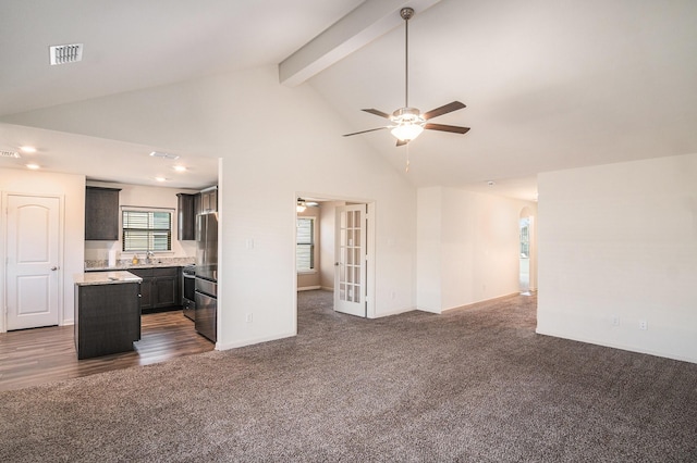 unfurnished living room with beam ceiling, a ceiling fan, visible vents, and dark colored carpet