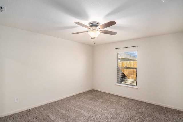 carpeted spare room with visible vents, baseboards, a textured ceiling, and ceiling fan