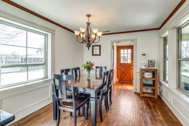 dining room featuring visible vents, dark wood-style floors, ornamental molding, and an inviting chandelier