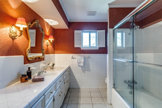 full bathroom featuring vanity, a wainscoted wall, wallpapered walls, tile walls, and tile patterned floors