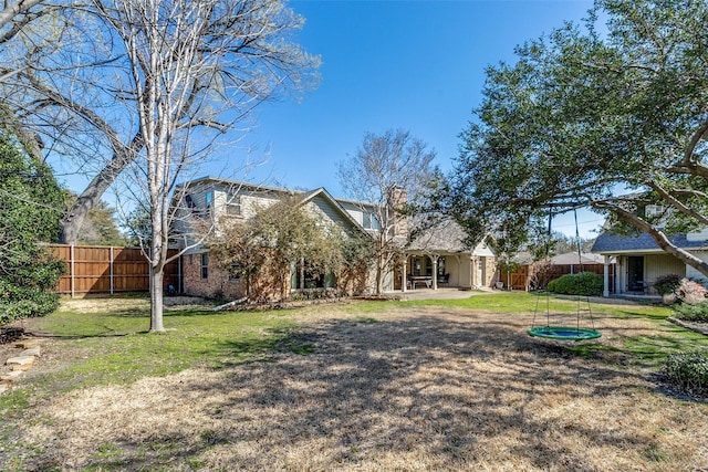 back of property with a patio, a yard, fence, and a chimney