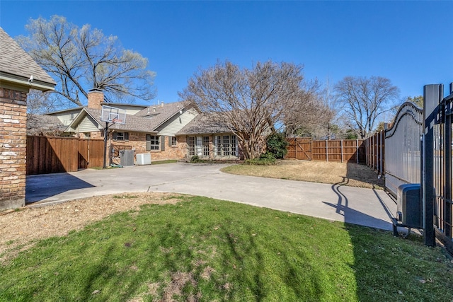 view of yard with a patio, central AC, and a fenced backyard