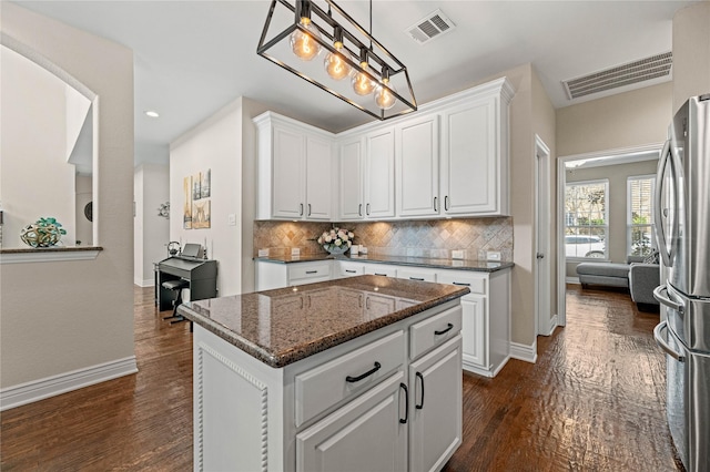 kitchen featuring visible vents, tasteful backsplash, dark wood finished floors, white cabinetry, and freestanding refrigerator