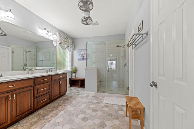 bathroom with a sink, double vanity, and a shower stall