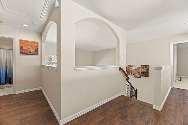 corridor featuring baseboards, an upstairs landing, attic access, and wood finished floors