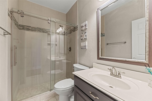 bathroom featuring a shower stall, toilet, a textured wall, tile patterned floors, and vanity