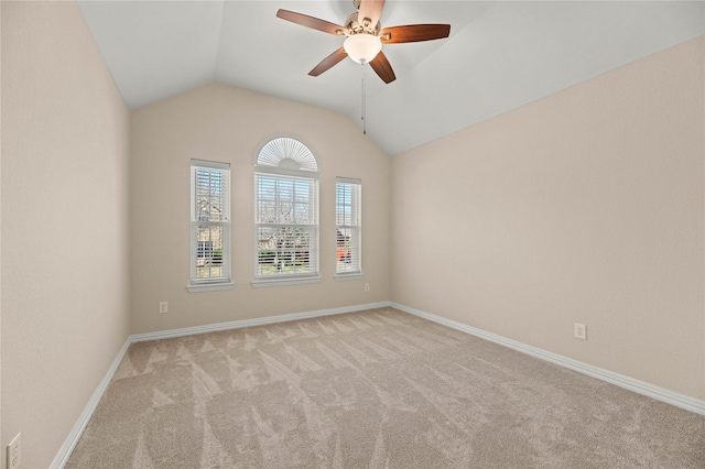 carpeted empty room featuring lofted ceiling, baseboards, and ceiling fan