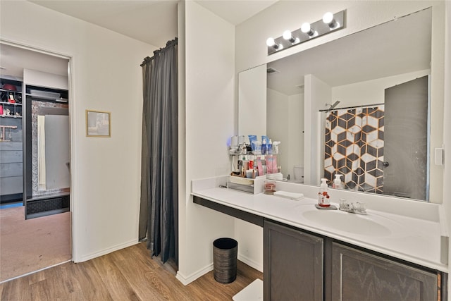 bathroom featuring vanity, a shower with shower curtain, baseboards, and wood finished floors